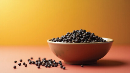 peppercorns in a bowl and some scattered on the floor