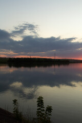 Fototapeta premium A body of water with a sunset in the background