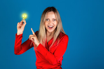 Concept of finding solution, eureka and idea. Happy woman in red dress has idea on blue background....