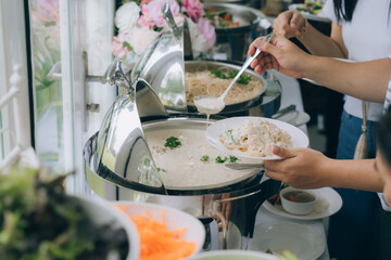 A Culinary Delight: An individual gracefully serves culinary dishes from buffet, offering a...