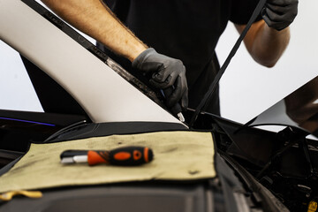 Removing residual adhesive after windshield removal. Technician scrapes off residual adhesive after...