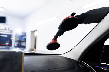 Windshield removal and installation using suction lifters. Windshield replacement using lifting...
