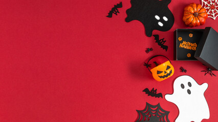Festive composition on the theme of Halloween, with a gift, ghosts and a pumpkin on a dark red...