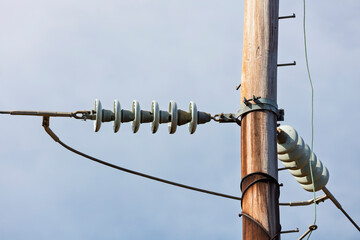 Photograph of aging and slightly deteriorating ceramic insulators on a high voltage electricity...