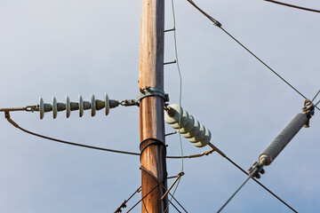 Photograph of aging and slightly deteriorating ceramic insulators on a high voltage electricity...