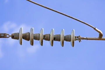 Photograph of aging and slightly deteriorating ceramic insulators on a high voltage electricity...