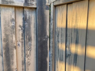 wooden fence door hinge hit by sunlight