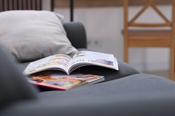 Lifestyle magazines on sofa indoors, closeup view