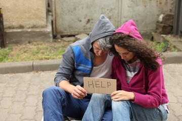 Poor homeless people with sign Help outdoors