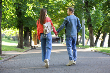 Obraz premium Lovely couple walking together in park on sunny day