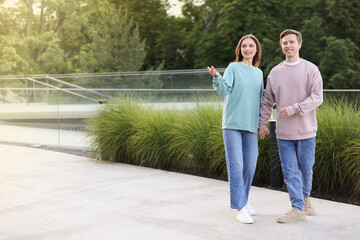 Obraz premium Lovely couple walking together on city street, space for text