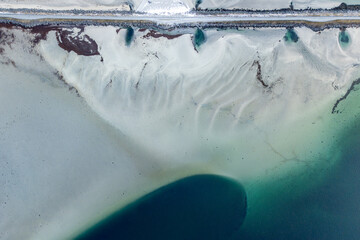 Karge K&uuml;stenlandscahft mit einer Strasse &uuml;ber den Damm mit weissem Sandstrand