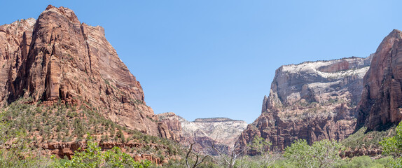 Snow-topped mountains sit beyond Zion&rsquo;s towering cliffs, captured in midday light from a wide canyon view, Zion, UT