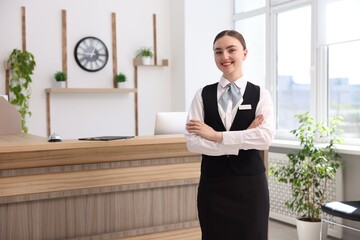 Portrait of smiling receptionist with crossed arms in hotel