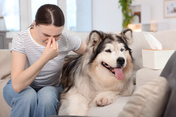 Woman suffering from allergy with her dog at home