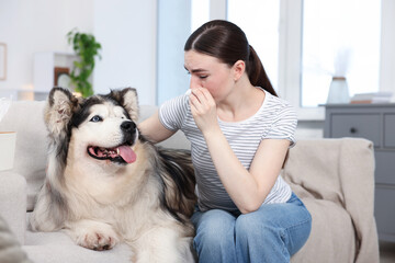 Woman suffering from allergy with her dog at home
