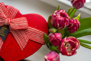Heart-shaped gift box with striped ribbon and 