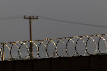 Barbed wire hedgehog and electric fence on top of a wall to protect a house in Brazil