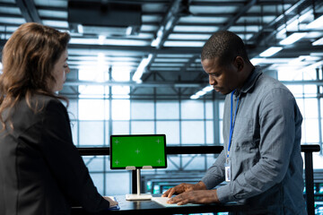System administrators in data center using isolated screen mockup tablet to verify settings....