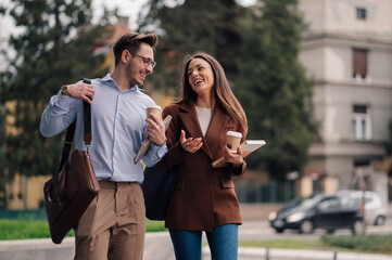 Business colleagues walking and talking during coffee break
