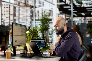 Middle eastern employee works on project development in the office, working on financial planning...