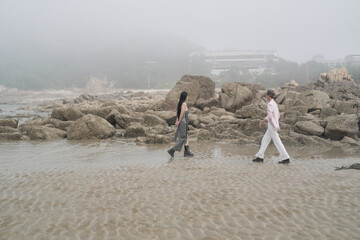 In June 2025, a Korean man and woman in their late fifties are playing together along the rocky...