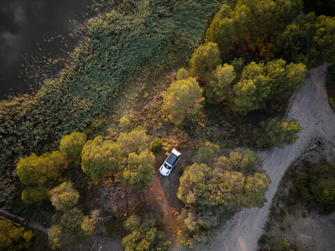Romantic Camping at the lake with 4x4 Offroad vehicle with roof tent at sundown