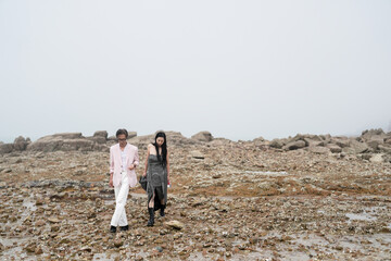 In June 2025, a Korean man and woman in their late fifties are playing together along the rocky...