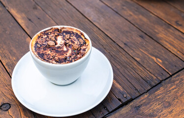 A cup of cappuccino with chocolate powder on a rustic wooden table in Brazil. Perfect for illustrating indulgence, simple pleasures, and coffee culture.