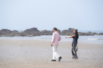 In June 2025, a Korean man and woman in their late fifties walk along the peaceful seashore, enjoying the soft ocean breeze, quiet moments, and each other's company in Incheon Metropolitan City.