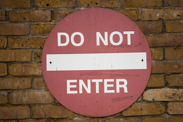 Red "DO NOT ENTER" sign mounted on a wall, serving as a clear warning or restricted access notice in a public or private area.