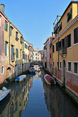 Streets and canals of Venice. Houses and boats, reflections in the water.