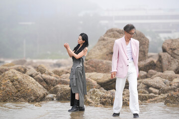 In June 2025, a Korean man and woman in their late fifties are playing together along the rocky...