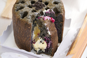 A sponge cake topped with rich Korean blueberries and whipped cream sits on a coastal cafe terrace....
