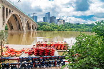 Georgetown waterfront in summer calm. Stacked kayaks, silent river and architecture blend along the river edge.