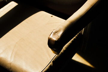 Close-up of a worn vintage train seat in warm sunlight
