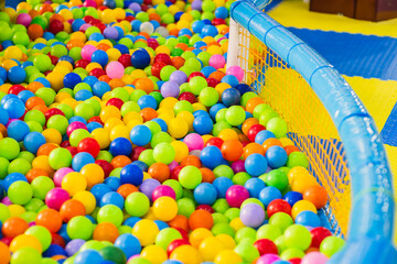 Brightly colored plastic balls in various shades fill a play area designed for childrens entertainment creating an inviting and playful atmosphere during daytime activities