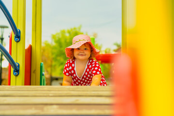 Child Playing on Colorful Playground Equipment During a Sunny Day in the Park
