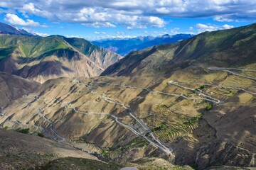 Aerial view of winding mountain roads through arid landscapes.