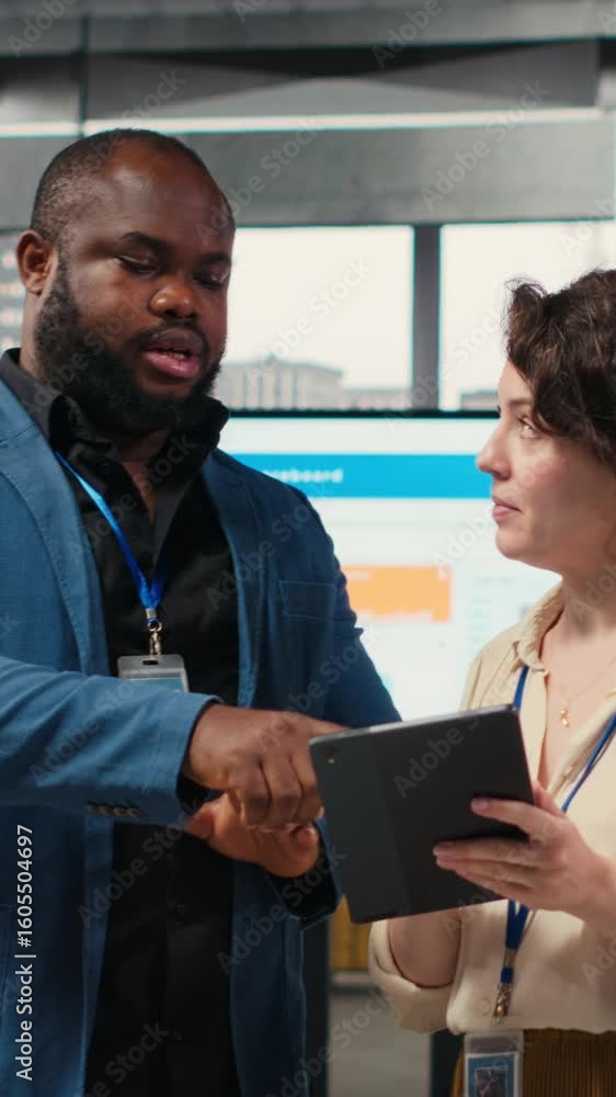 Poster vertical video two employees reviewing data insights on tablet in professional workspace, developing