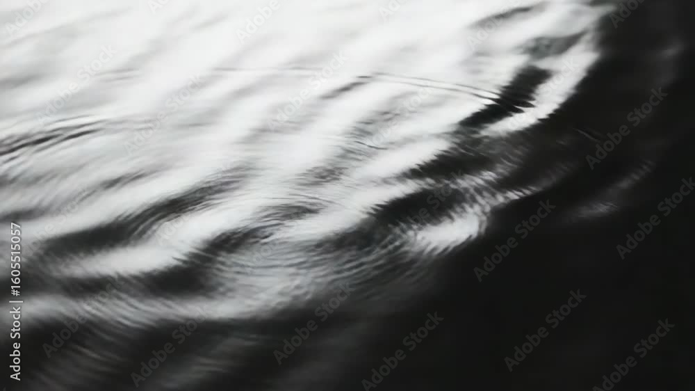 Poster water droplets on a wet surface, reflections of light creating patterns in water.