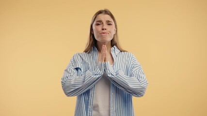 Young pretty woman praying with palms in sincere silent request. Hope, faith