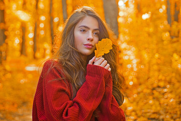 Portrait of woman with autumn leaf on face. Woman portrait close up on autumn background. Woman face with autumn leaves. Beauty girl in autumn fall leaves park. Girl autumnal mood. Foliage, falling