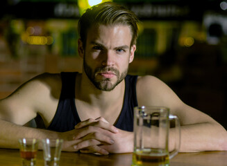 Man sitting alone in pub. Man with alcohol. Sad guy in bar. Guy in dark bar. Alcohol problem. Lonely man drinking whiskey at restaurant. Depressed man with glass of beer. Nightlife club.