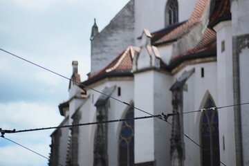 gothic church, tram wires, historic architecture, city infrastructure, stained glass, old building, urban landscape, medieval style, European city, power lines, cultural heritage, travel