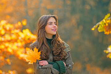 Woman walking outdoors in autumn day. Woman on autumn background. Woman with autumn leaves. Girl in autumn fall leaves park. Girl on autumnal fall background. Foliage, falling leaves.