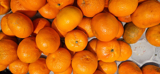 Fresh, ripe oranges with a vibrant orange color, arranged naturally. The fruit's smooth, glossy...