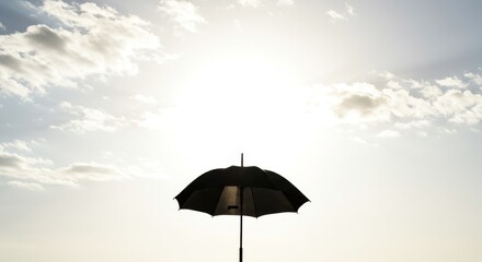 Silhouette of a Black Umbrella Against a Bright Sunny Sky
