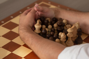 Close up of hands of middle aged caucasian man playing chess. 
