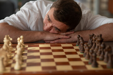 Middle aged Caucasian man playing chess. 